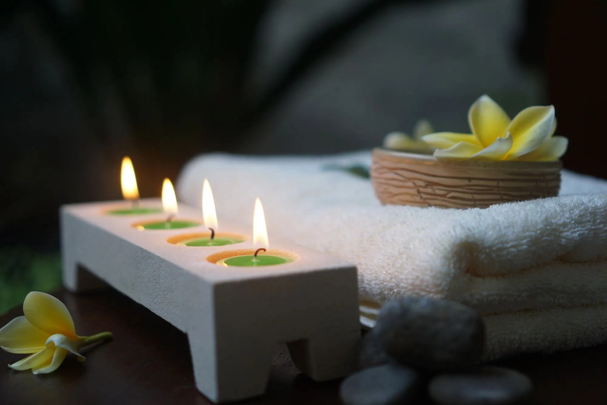 Lit candles and folded towels in a spa room