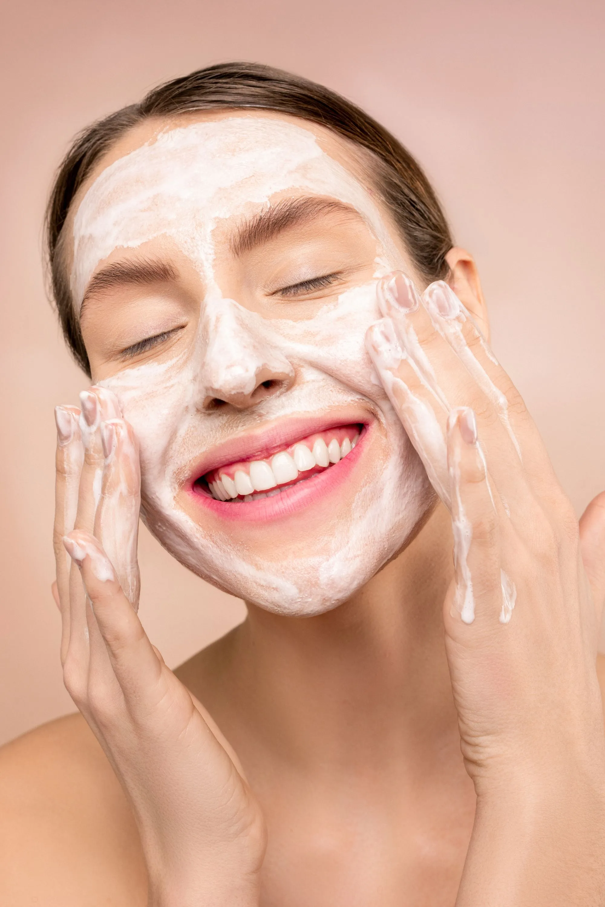 Smiling woman cleansing her face