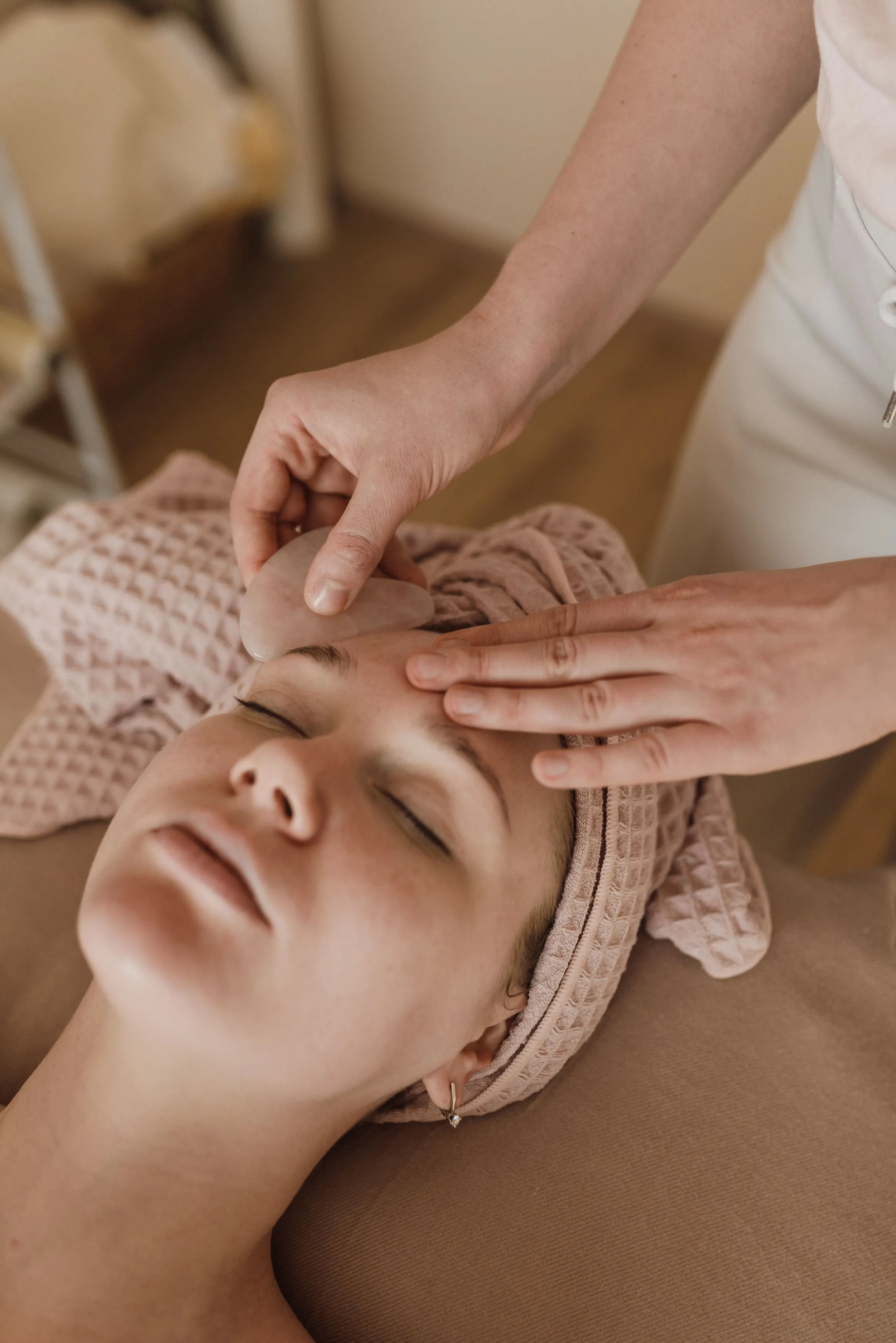 Aesthetician massaging a client's face during a facial
