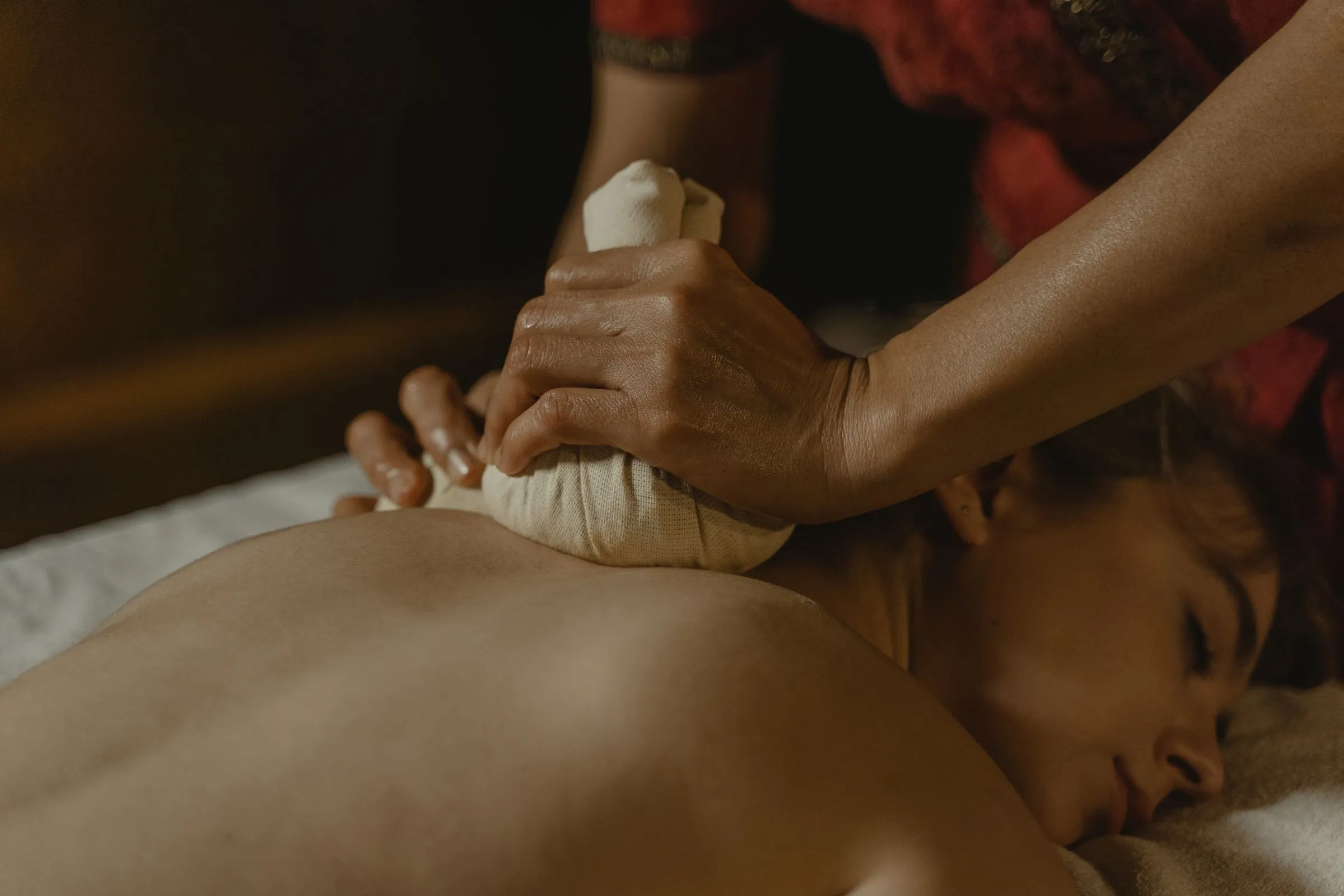Herbal compress massage on a client's back