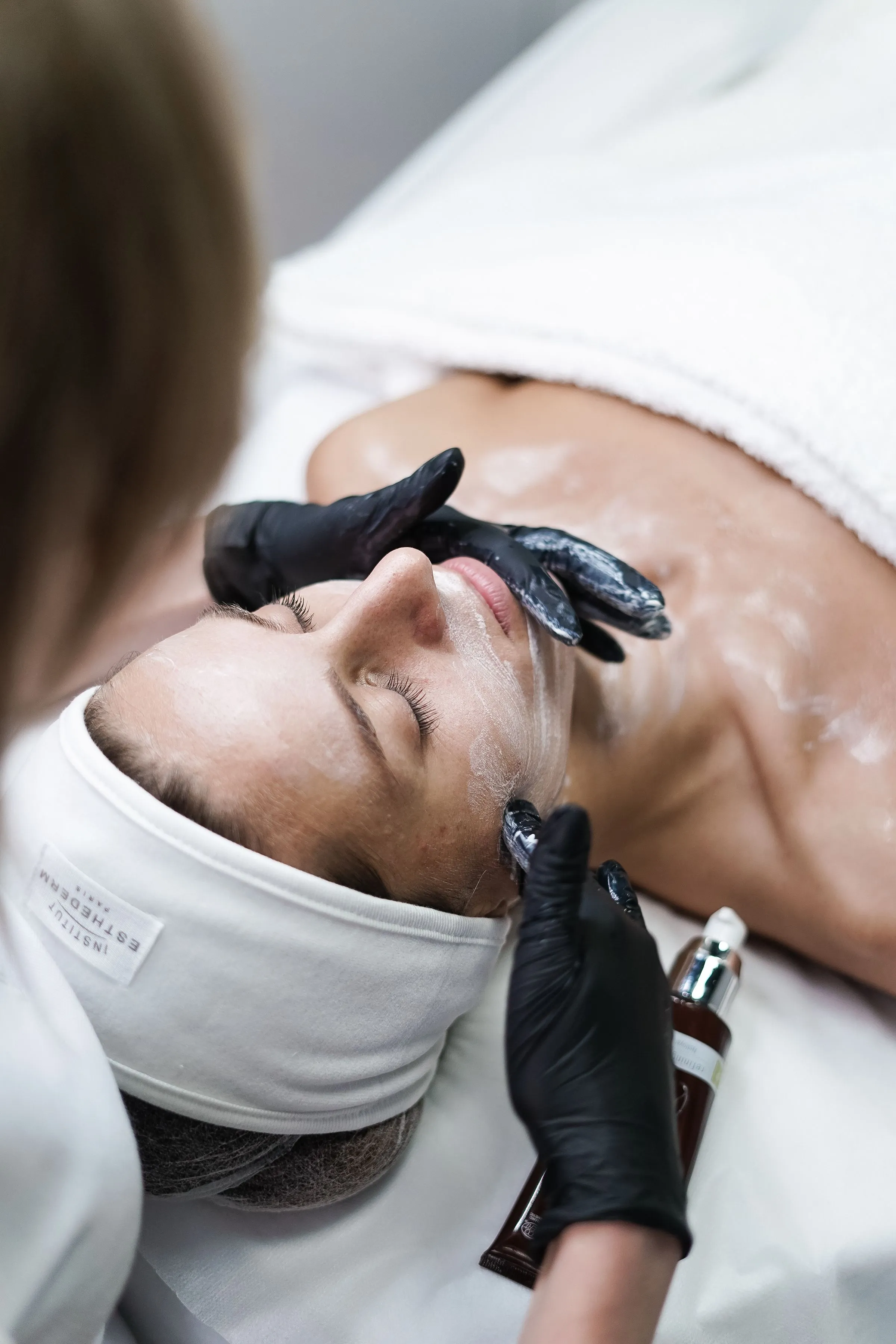 Aesthetician removing a clay mask