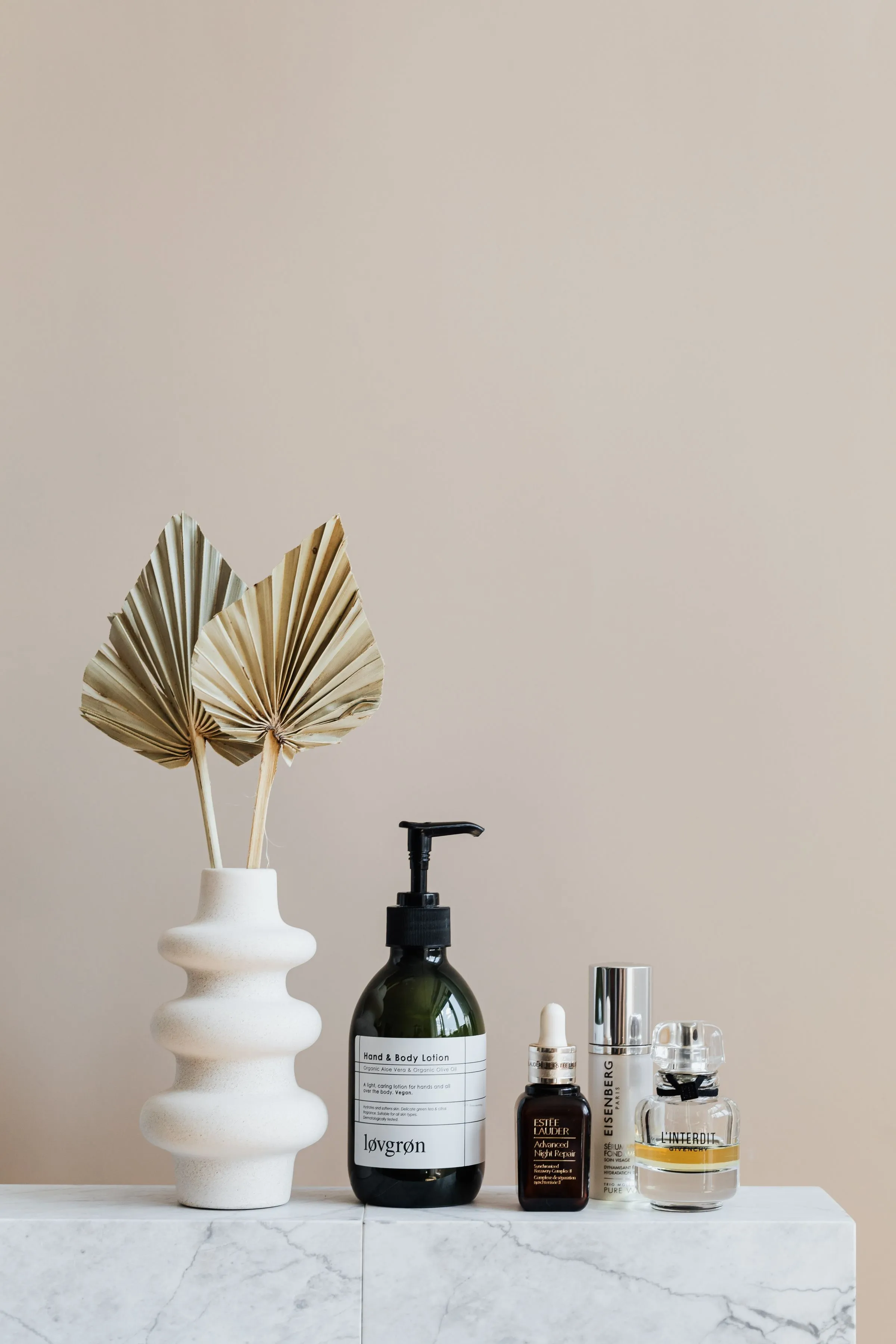 Skin care bottles on a marble shelf