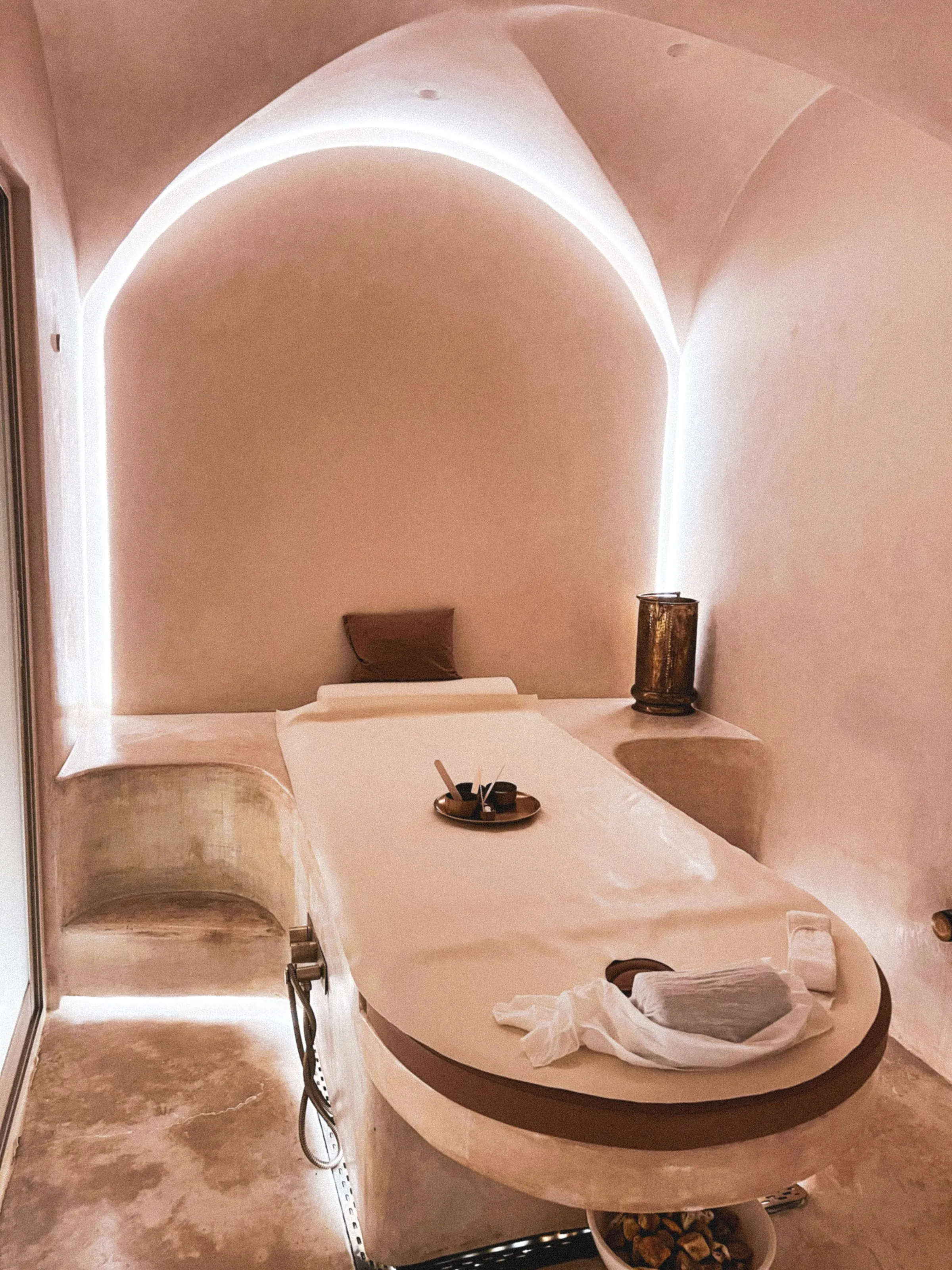 Softly lit treatment room with a massage bed